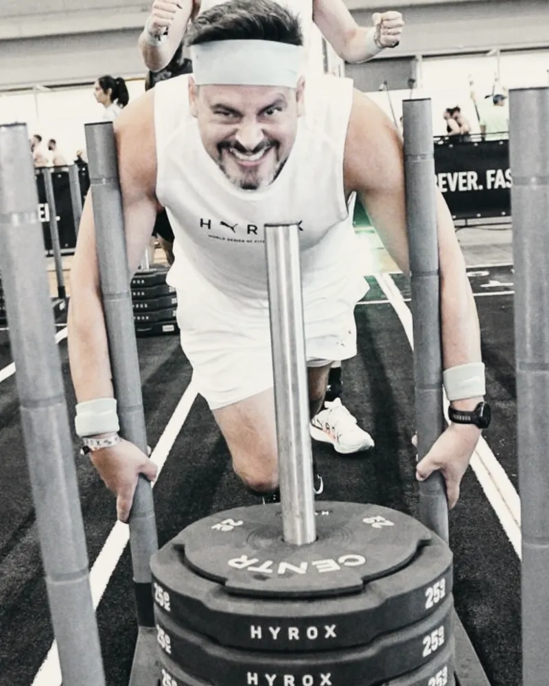 Oliver Sonntag schiebt beim Fitness-Wettkampf HYROX einen beladenen Schlitten
